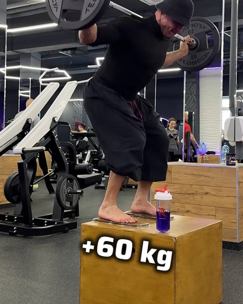 Ivan box-squatting a loaded barbell, plus 60kg, in the gym